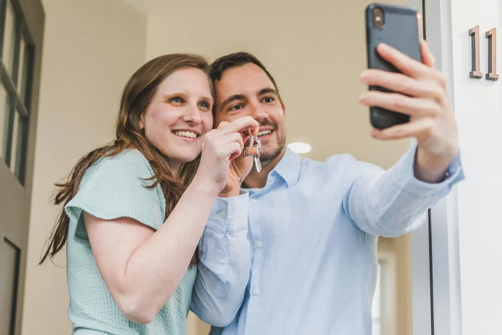 Couple holding keys to their first home, celebrating a successful purchase in Perth
